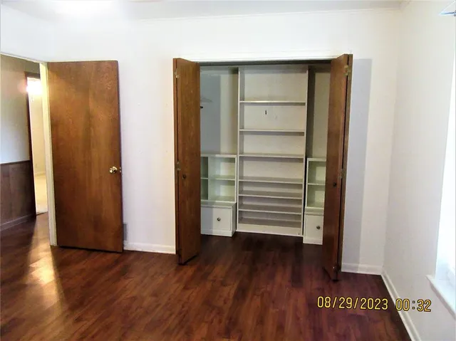 an empty room with wooden floor and closet