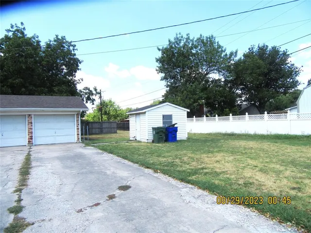 front view of house with a yard and potted plants
