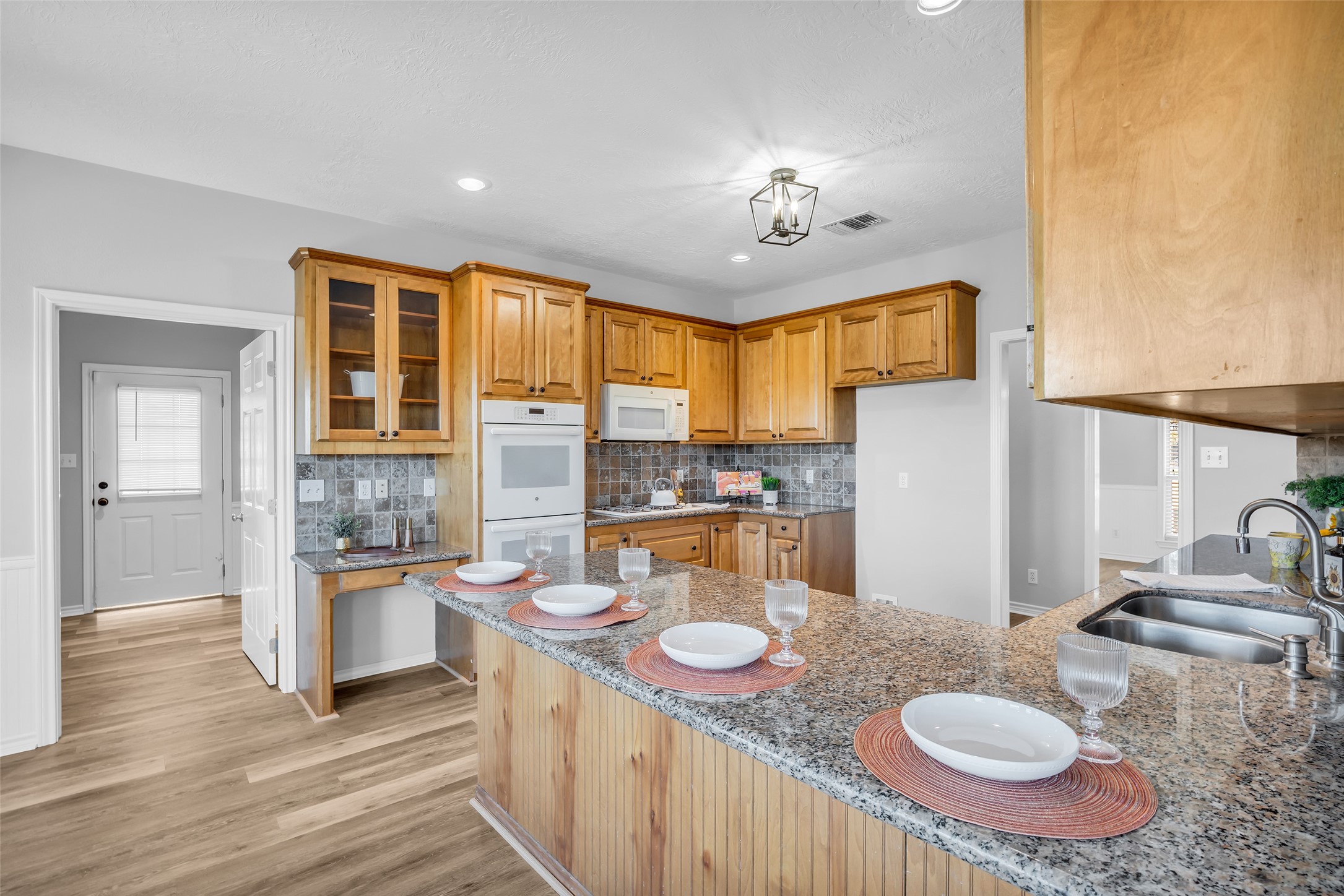 1075 Harrisburg Road Brenham, TX 77833 - Photo 16 of 49 a open kitchen with stainless steel appliances granite countertop a sink and dishwasher a dining table with wooden floor
