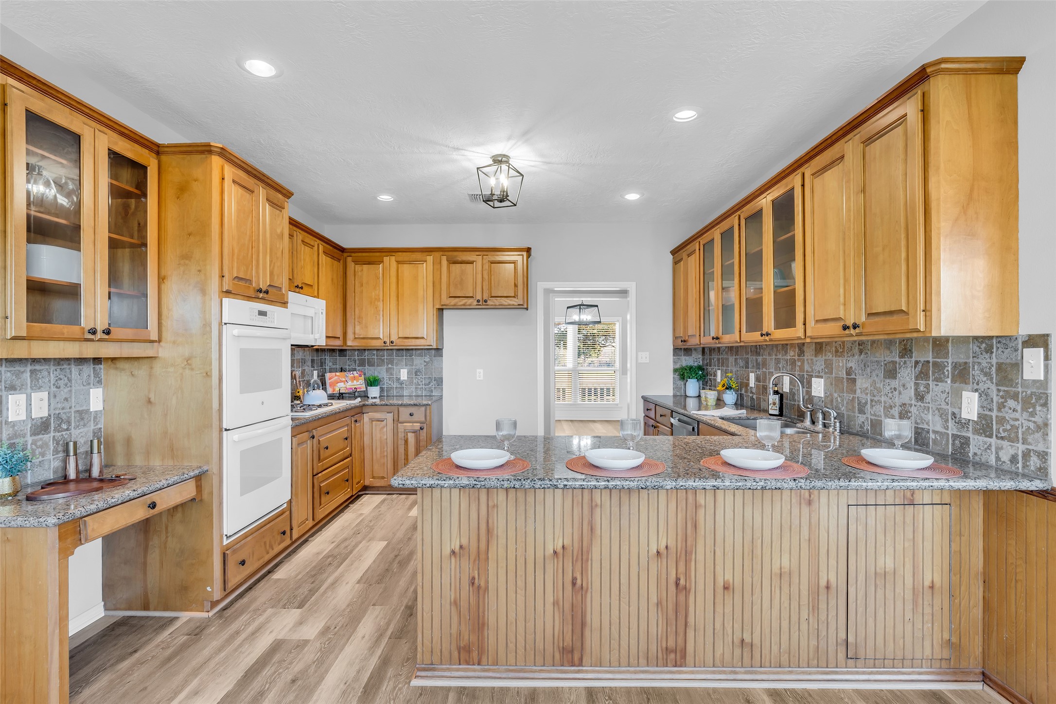 1075 Harrisburg Road Brenham, TX 77833 - Photo 17 of 49 a kitchen with granite countertop wooden floors a refrigerator and cabinets