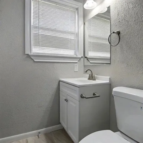 a bathroom with a sink a toilet and a window