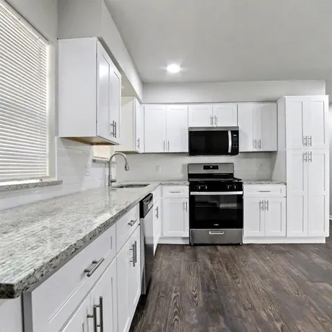 a kitchen with granite countertop a sink and steel appliances