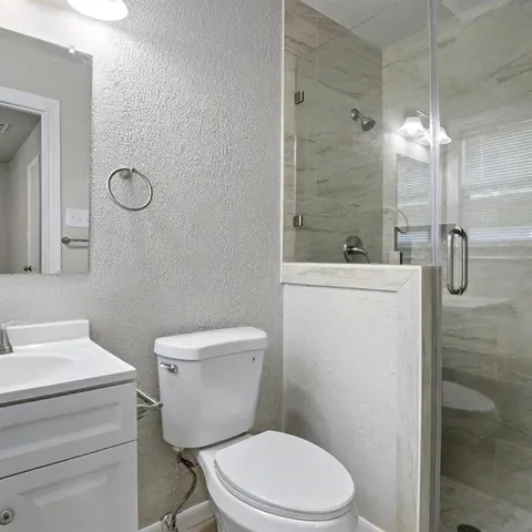 a white toilet sitting next to a bathroom sink