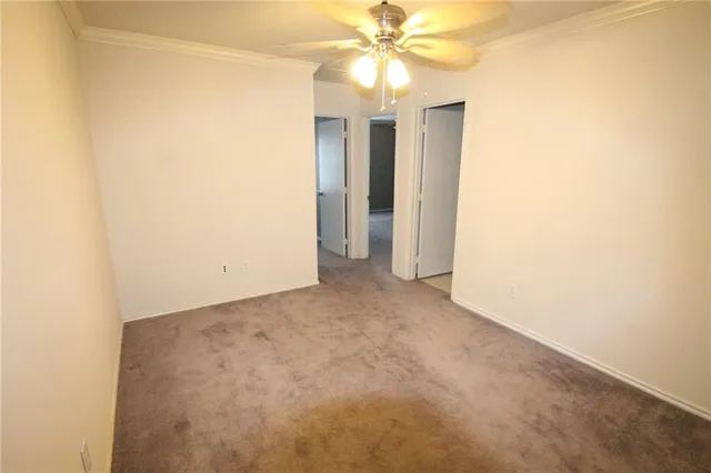 an empty room with a ceiling fan and a window
