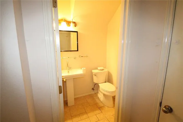 a bathroom with a granite countertop toilet and a sink