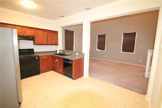 a kitchen with stainless steel appliances granite countertop a stove top oven sink and cabinets