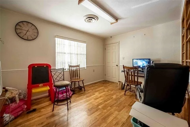a view of a hallway with wooden floor and a window
