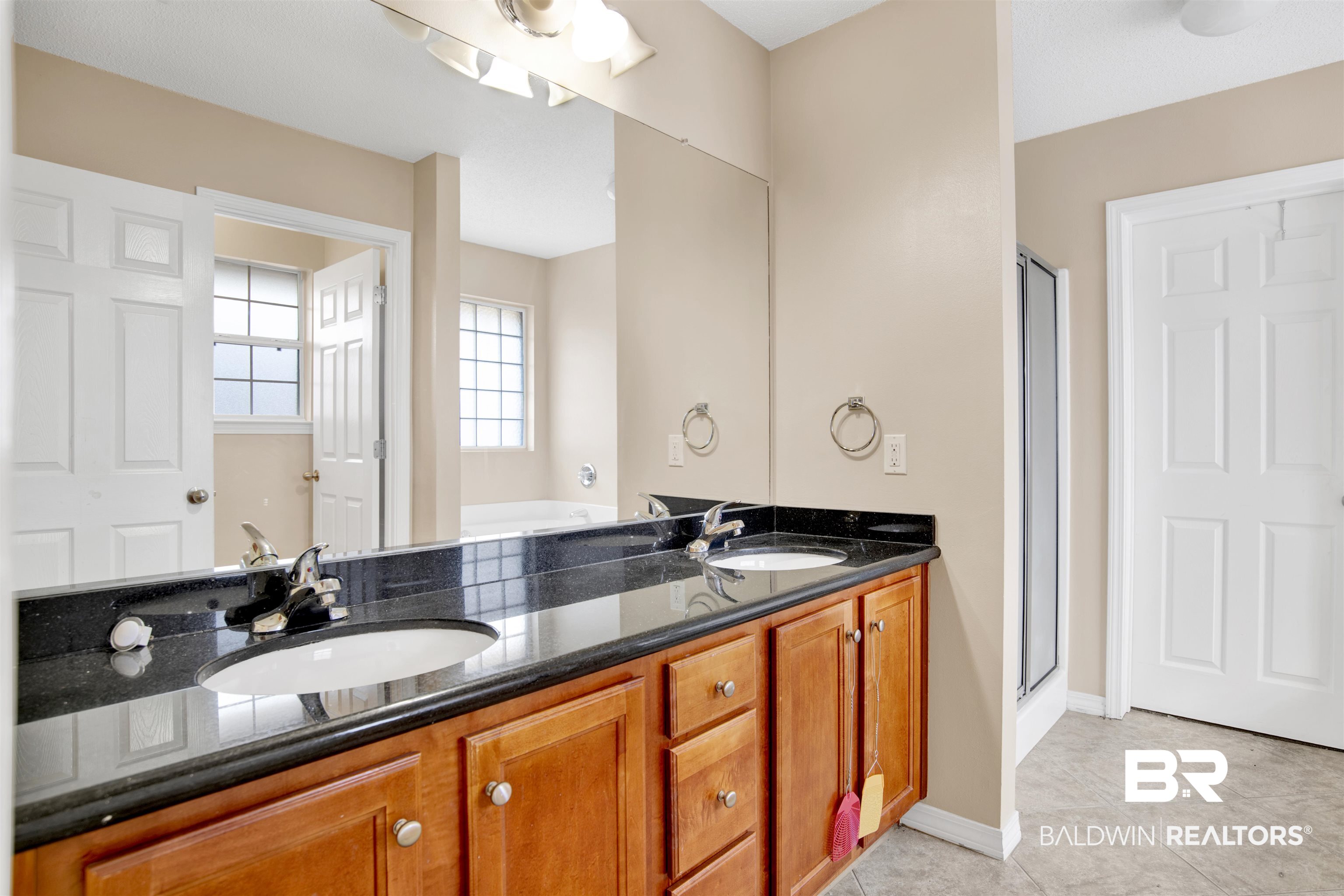 7297 Bridgemill Drive Mobile, AL 36619 - Photo 22 of 33 Bathroom featuring double vanity, a stall shower, and light tile patterned flooring