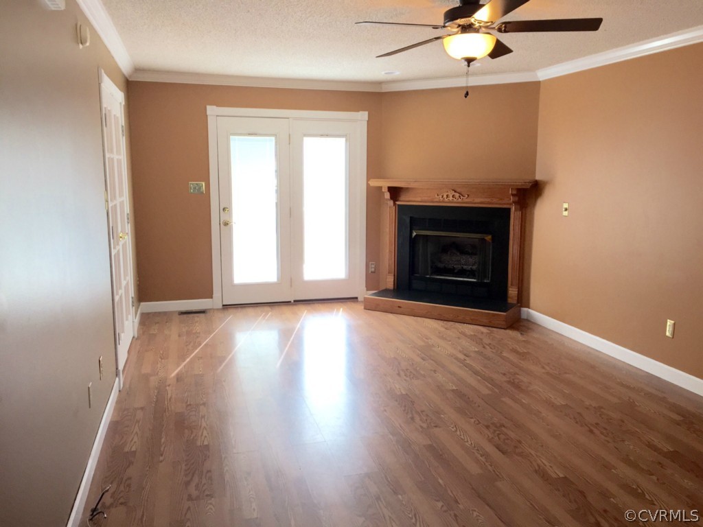 17941 Loving Union Road Disputanta, VA 23842 - Photo 6 of 17 an empty room with wooden floor a ceiling fan and windows