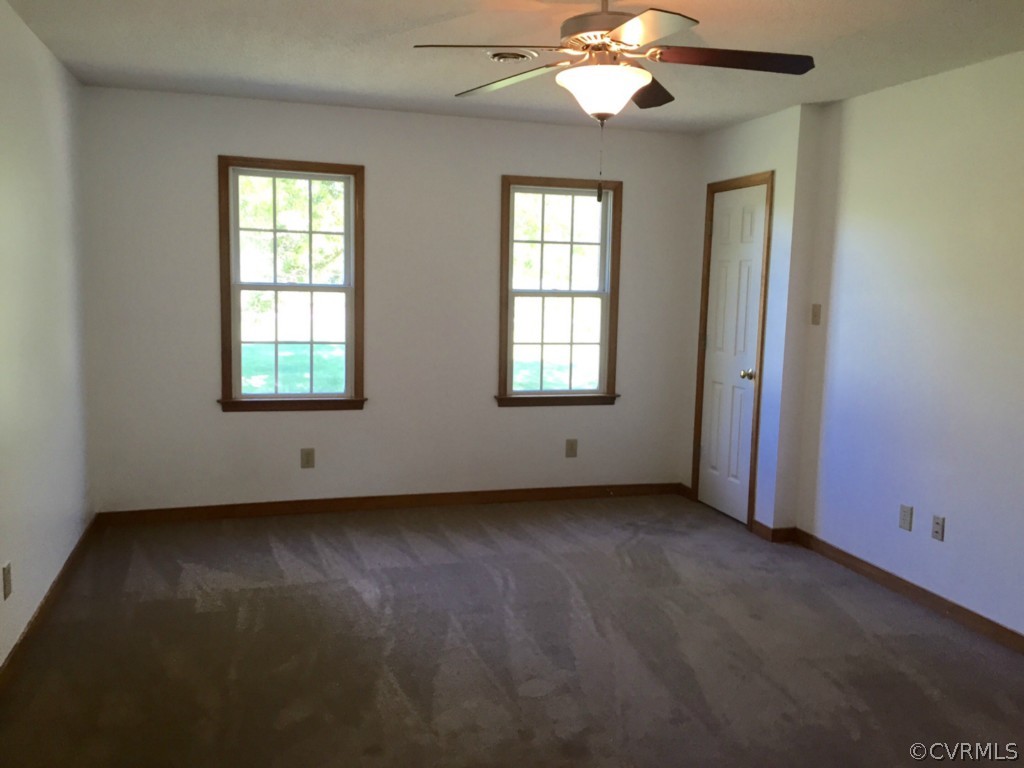 17941 Loving Union Road Disputanta, VA 23842 - Photo 8 of 17 an empty room with chandelier fan and windows