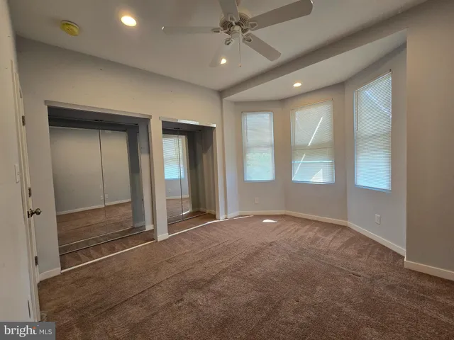 a view of empty room with window and ceiling fan