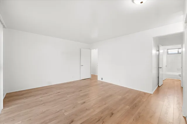 a view of an empty room with wooden floor
