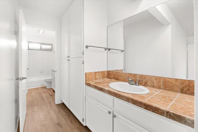 a bathroom with a granite countertop sink and a mirror