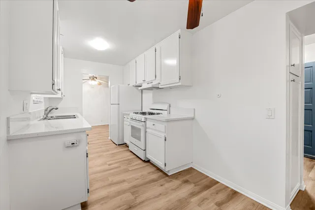 a kitchen with cabinets wooden floor and a sink