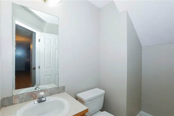 a bathroom with a toilet a sink and mirror