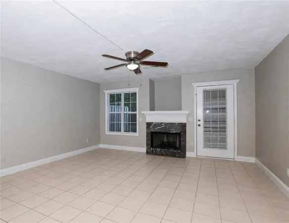 a view of an empty room with a fireplace and a window