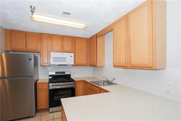 a kitchen with stainless steel appliances white cabinets and a refrigerator