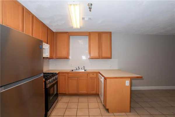 a kitchen with a sink a stove cabinets and a window
