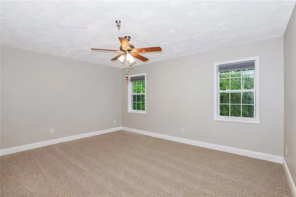 an empty room with a window and a fan