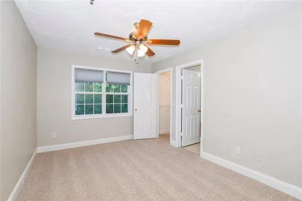 an empty room with windows and fan