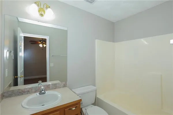 a bathroom with a sink vanity mirror and toilet