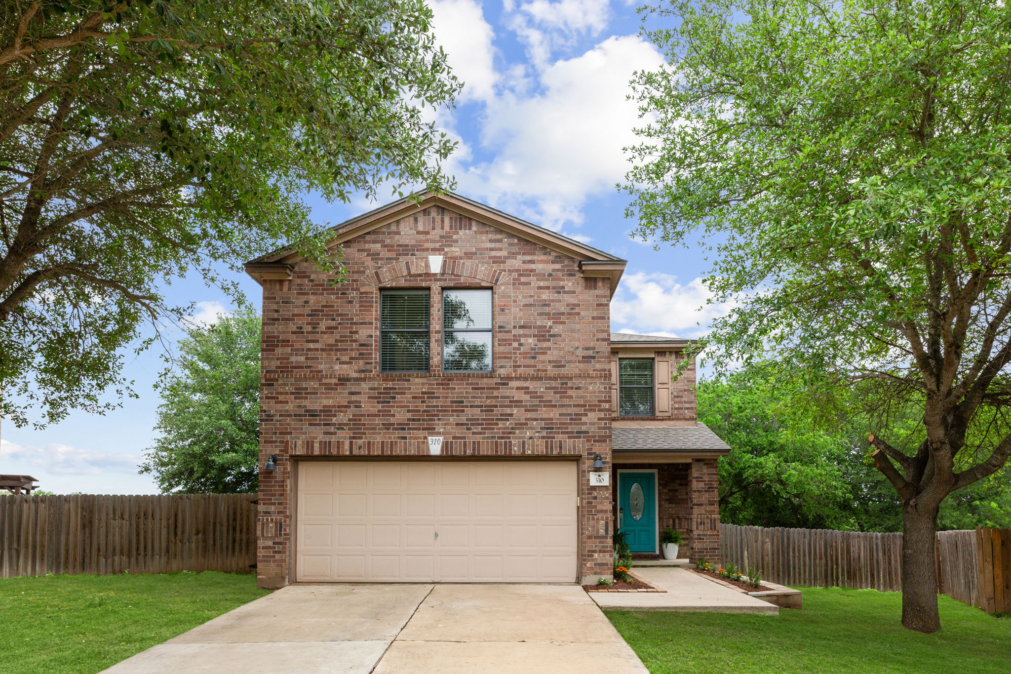 a front view of house with yard and trees in the background
