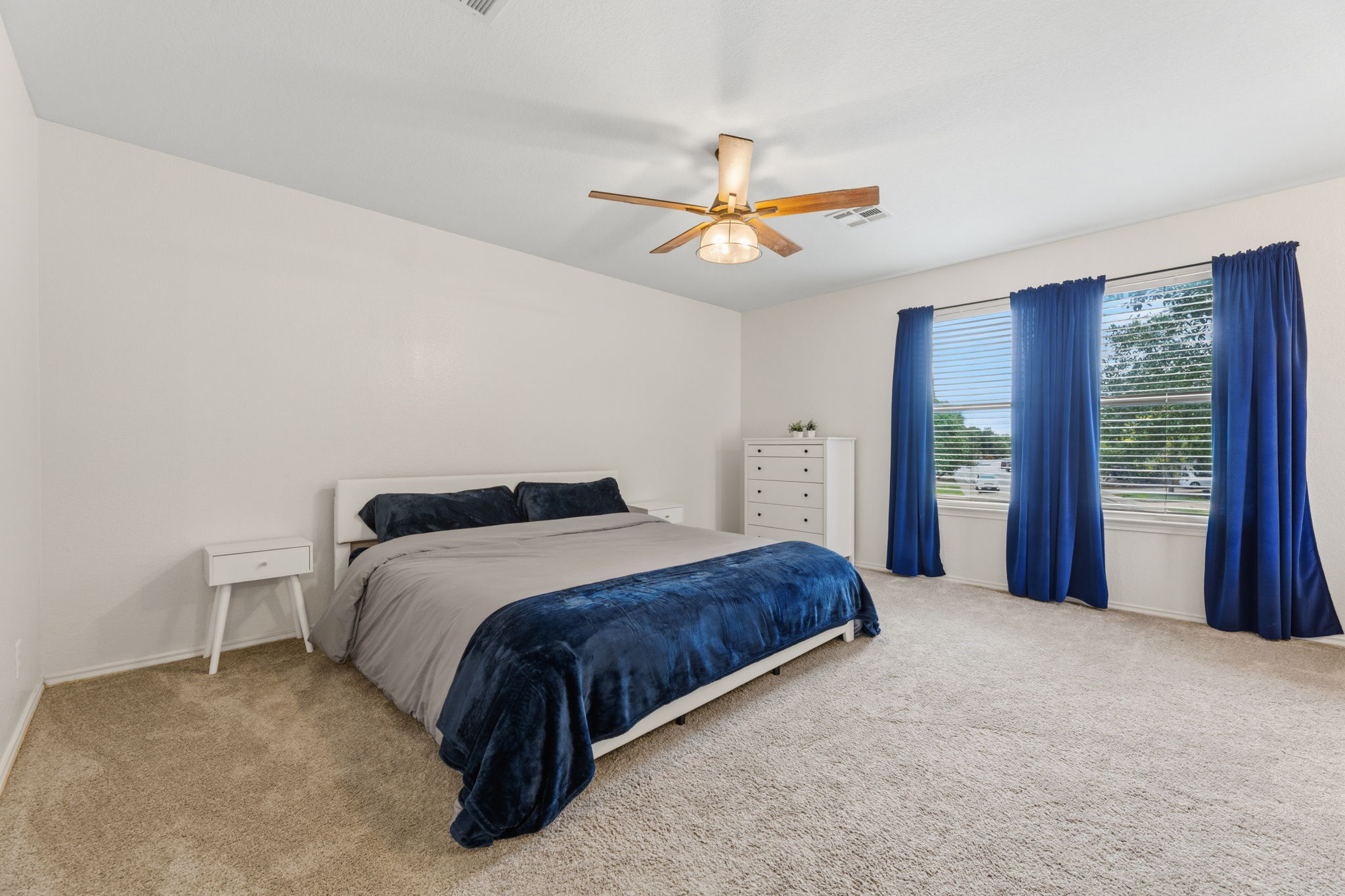 310 Myrtle Street Kyle, TX 78640 - Photo 17 of 39 a bedroom with a large bed and a chandelier