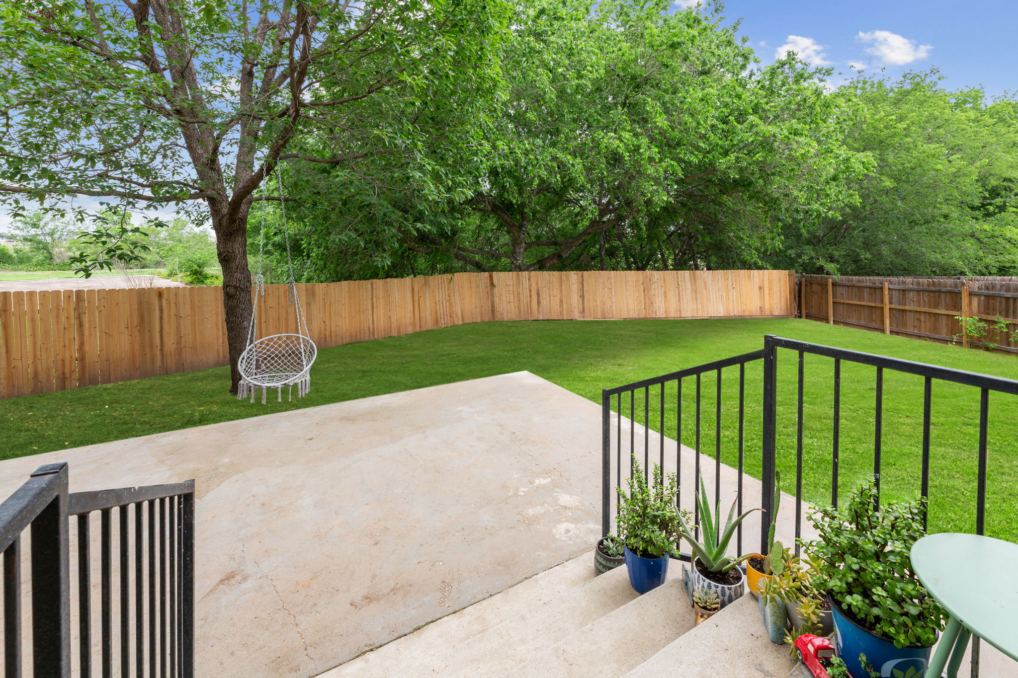 310 Myrtle Street Kyle, TX 78640 - Photo 25 of 39 Spacious backyard with endless possibilities featuring a concrete patio, and a tall privacy fence. (green grass photography edit)