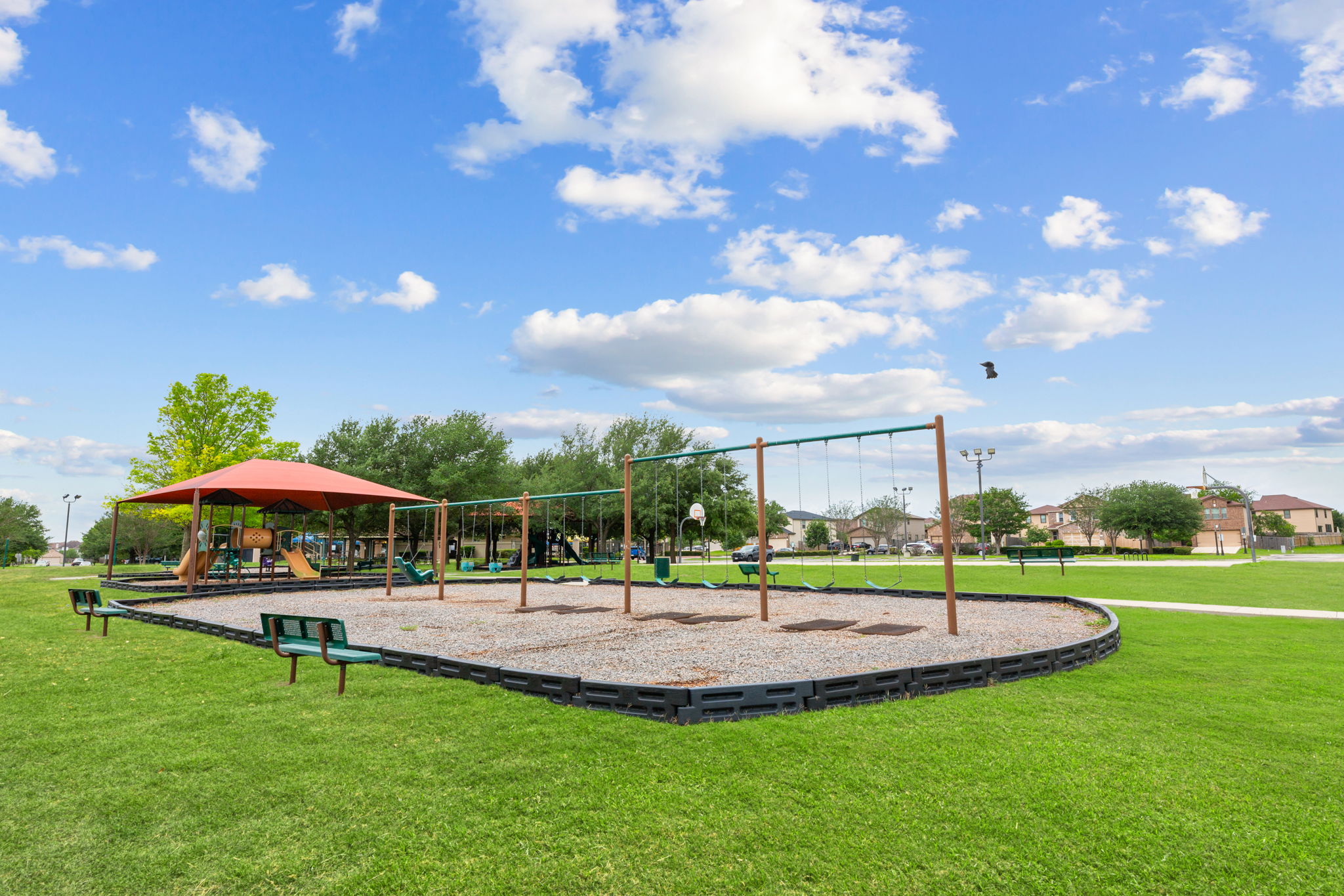 310 Myrtle Street Kyle, TX 78640 - Photo 36 of 39 Community park featuring a large play structure with slides, a swing set, covered seating areas, and expansive green spaces