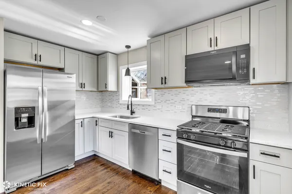 a kitchen with stainless steel appliances granite countertop a stove a refrigerator and a microwave