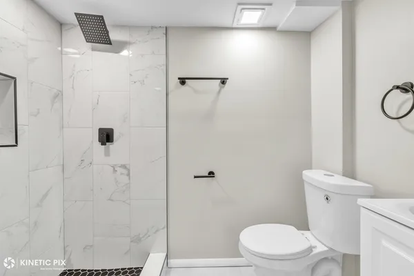 a white toilet sitting next to a shower