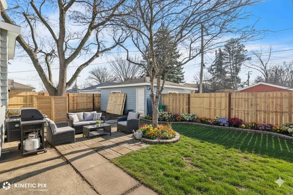 a view of a backyard with furniture and garden