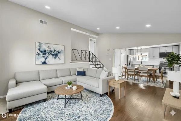 a living room with furniture wooden floor and a large window