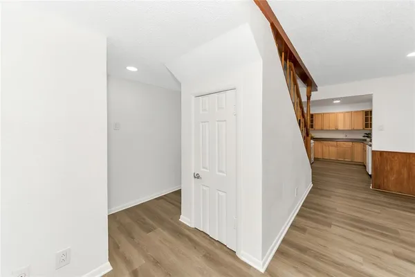 a view of a hallway with wooden floor and staircase