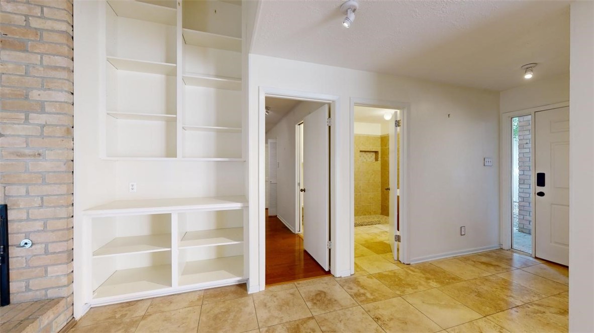 3004 Gleneagles Court Bryan, TX 77802 - Photo 12 of 38 a view of an empty room with wooden floor and a bathroom