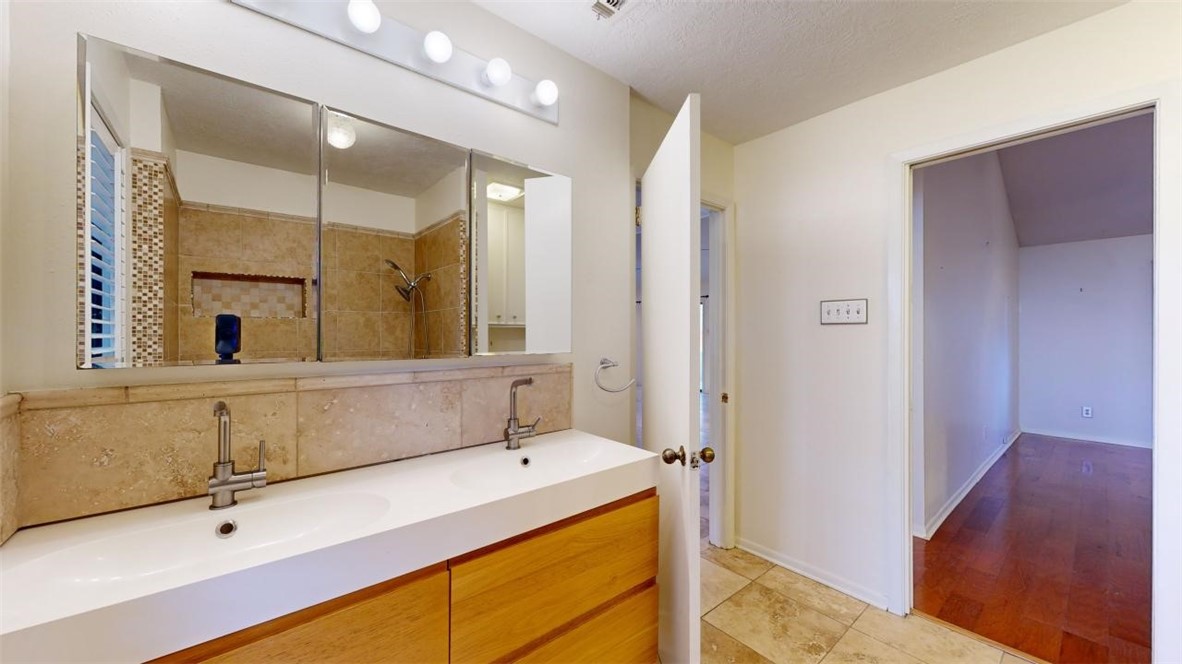3004 Gleneagles Court Bryan, TX 77802 - Photo 19 of 38 a bathroom with a double vanity sink and mirror