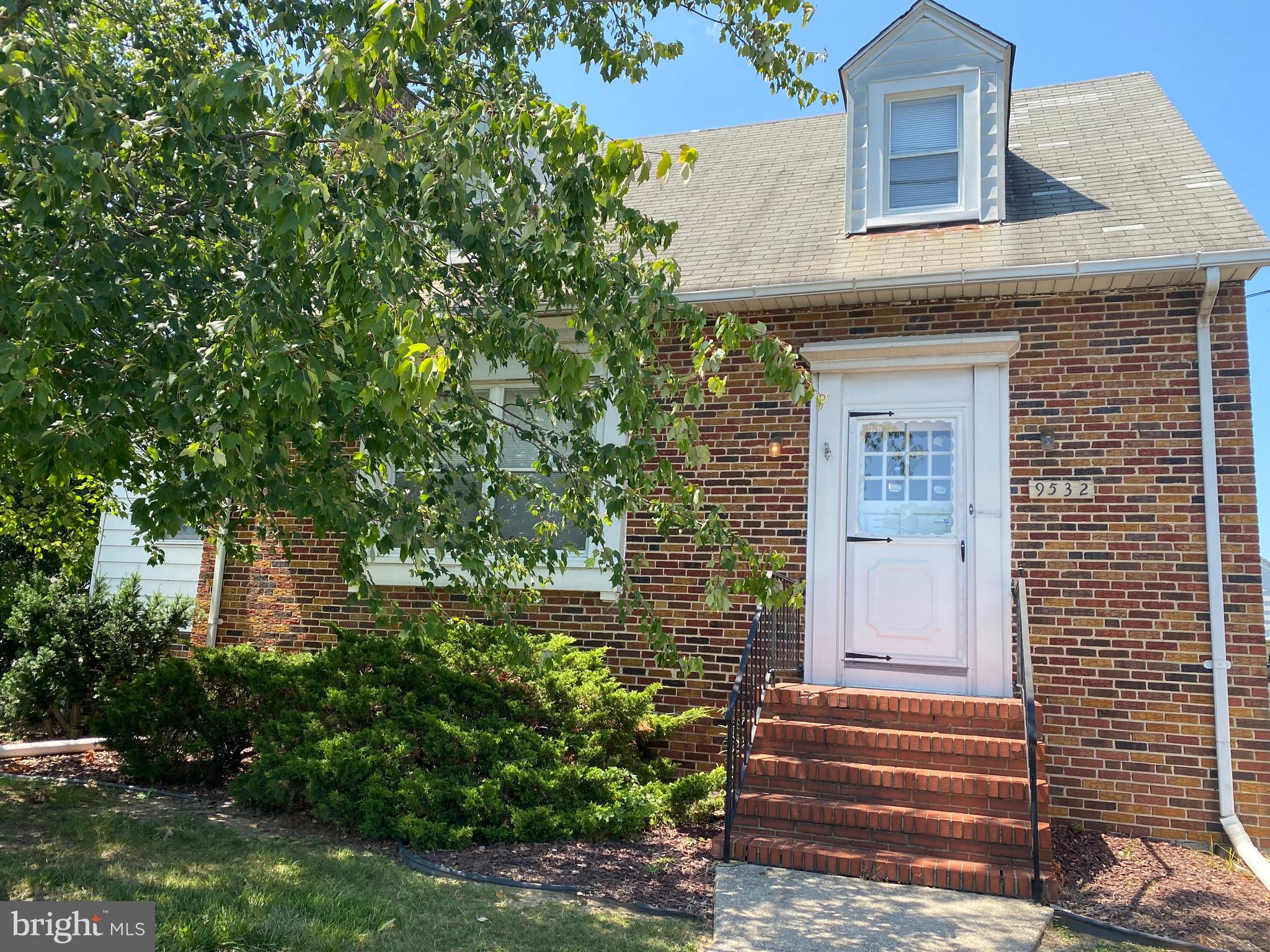 a front view of a house with plants