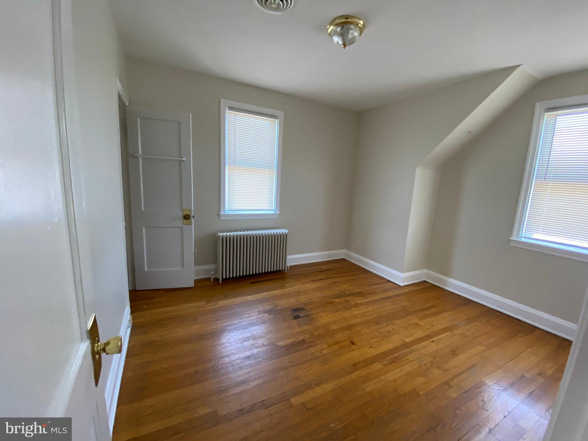 9532 Belair Road Baltimore, MD 21236 - Photo 13 of 20 a view of an empty room with wooden floor and a window