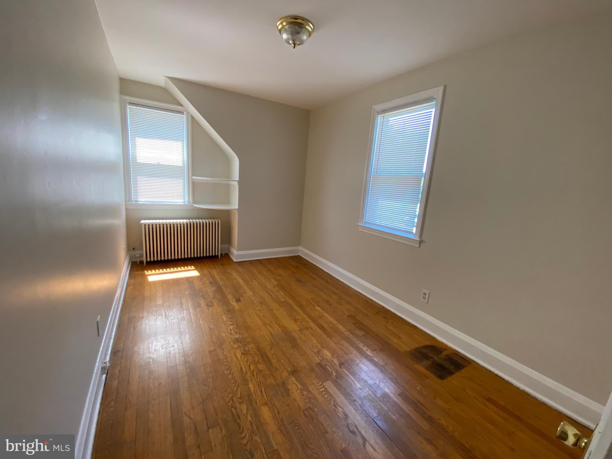 9532 Belair Road Baltimore, MD 21236 - Photo 14 of 20 an empty room with wooden floor and windows