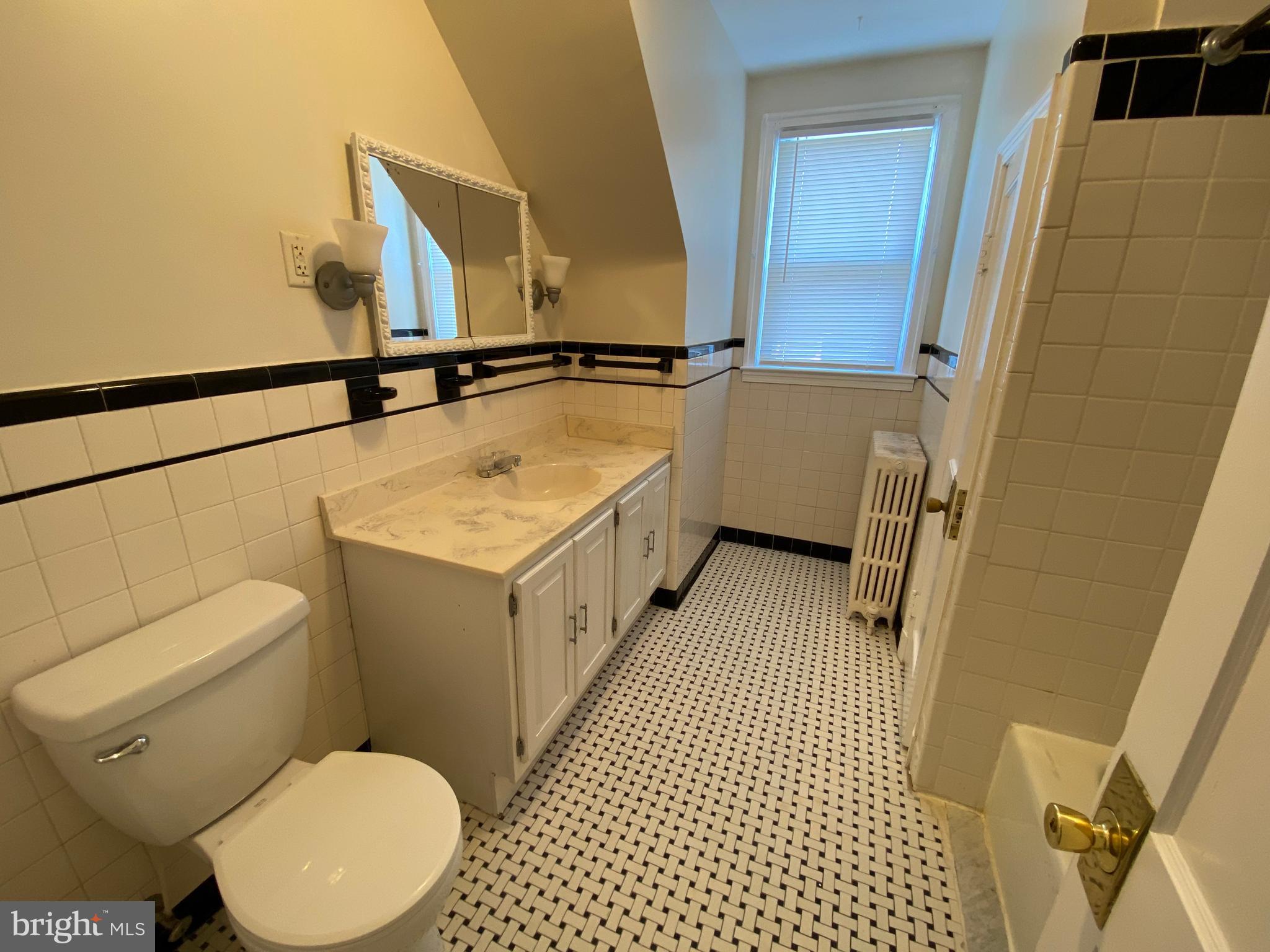 9532 Belair Road Baltimore, MD 21236 - Photo 17 of 20 a bathroom with a sink a toilet a mirror and shower