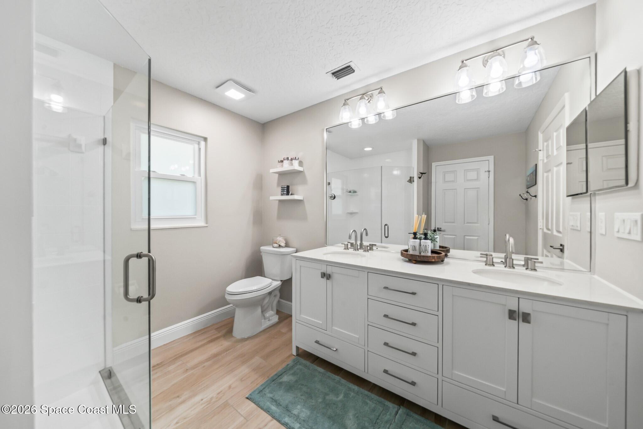 697 Spring Lake Drive Melbourne, FL 32940 - Photo 23 of 45 a spacious bathroom with a double vanity sink a mirror and a shower