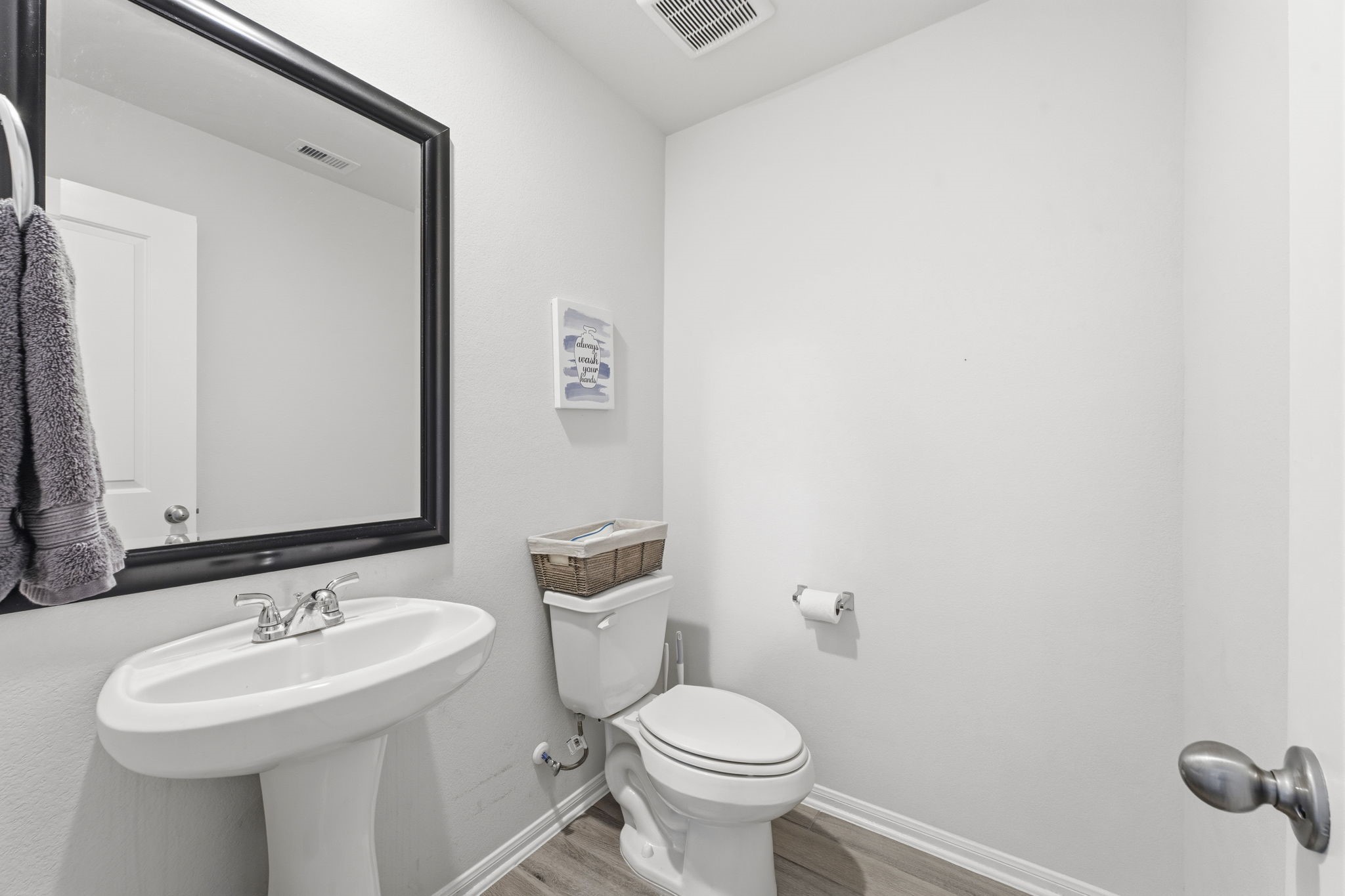 2401 Abbot Brk Drive Rosharon, TX 77583 - Photo 24 of 50 The guest powder room on the first floor boasts wood-look tile flooring, pedestal sink, commode, and framed mirror.