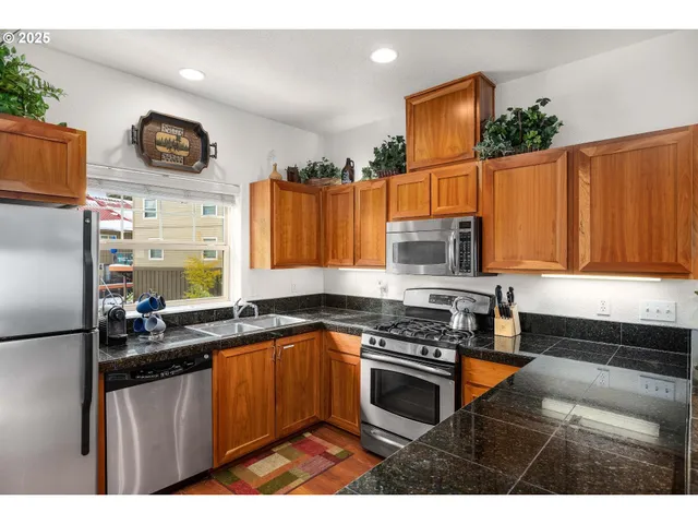 a kitchen with granite countertop a sink a stove and cabinets