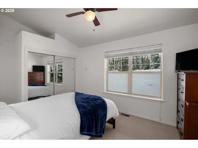 a bedroom with a bed a dresser and a chandelier