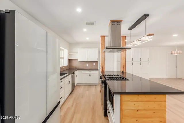 a kitchen with stainless steel appliances granite countertop a stove and a refrigerator