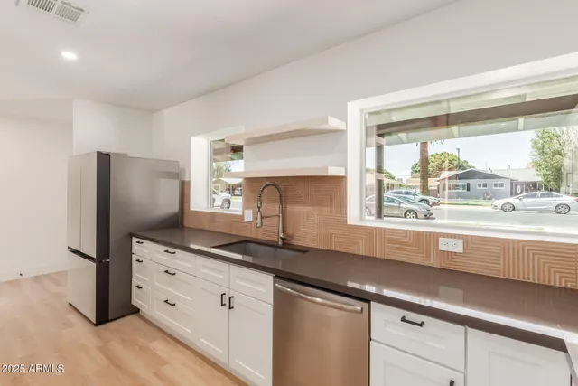 a kitchen with granite countertop a refrigerator and a sink