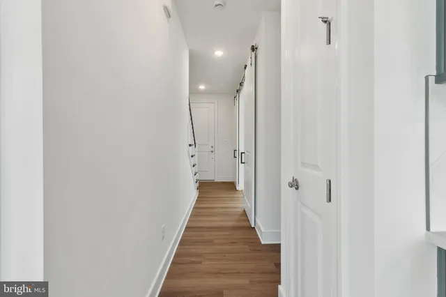a view of a hallway with wooden floor and closet