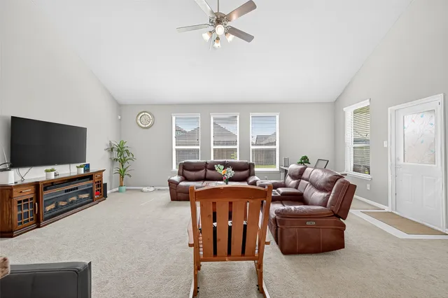 a living room with furniture and a ceiling fan