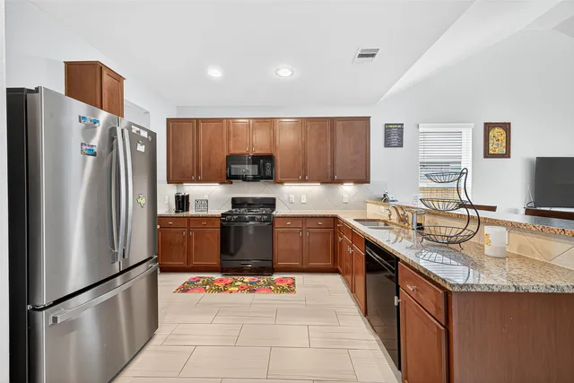 a kitchen with stainless steel appliances granite countertop a sink stove and microwave