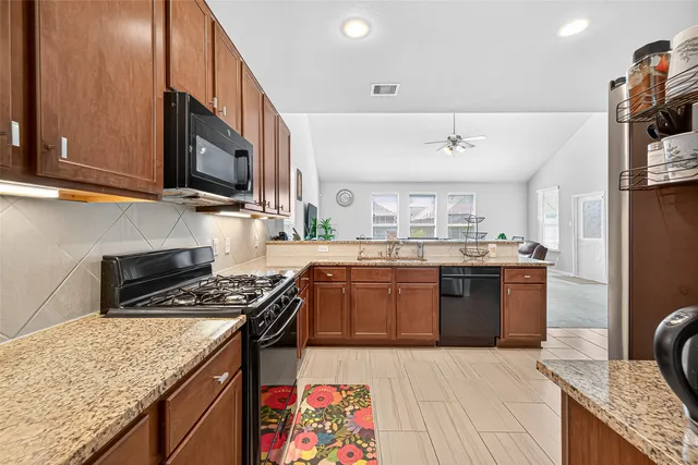 a kitchen with granite countertop cabinets stainless steel appliances and wooden cabinets